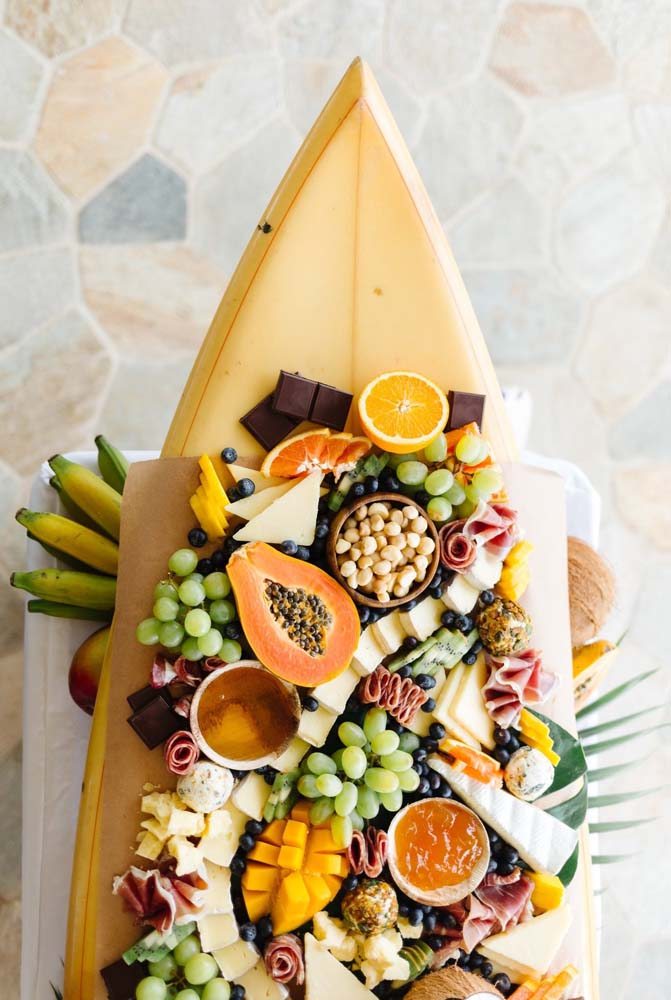 Uma mesa de frutas a la praia: com uma prancha de surf para sustentar esse mar de cores!